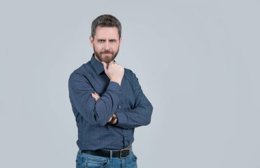 Tarzından taviz vermeden. Orta yaşlı bir adam sakallı çeneye dokunuyor. Sıradan bir tarzı var. Moda erkek giyim. Moda erkek gardırobu. Nihai rahatlık için, boşluğu kopyala