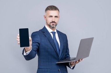 Adam bilgisayar ve akıllı telefon kullanıyor. Girişimci ya da yönetici. Çevik iş. Profesyonel ağ yöneticisi dizüstü bilgisayarı ve telefonu beklet. Webinar reklamı. Olgun iş adamları internette çalışıyor. iş başarısı.