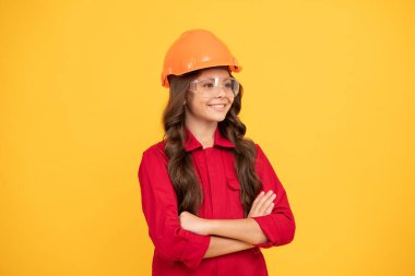 Koruyucu şapkalı neşeli kız ellerini çaprazladı, gelecekteki kariyeri....