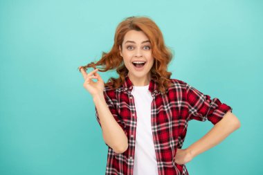 Kıvırcık saçlı, gülümseyen kadın. moda ve güzellik. Kadın model gündelik trend. Genç bir kızın portresi. Kızıl saçlı kadın. Kareli gömlekli mutlu kızıl kadın. pozitif duyguları ifade et.