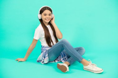 Mutlu çocuk müzik dinliyor kablosuz kulaklıkla, modern kulaklıkla.