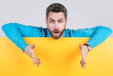 Boş sarı kağıt pankartın arkasına sakallı bir adam şaşırdı. Fotokopi alanı olan, bilgi jestleri yapan, ürün sunan..