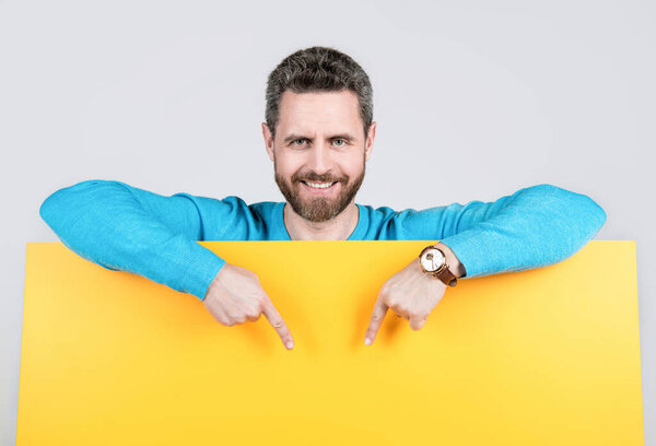 объявление. покупки и скидки. Представление продукта. представление новизны информации. изумленный мужчина за желтой бумагой. Удивительный человек с копировальным пространством для рекламы. Парень реклама.