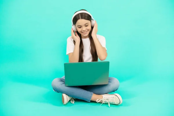 소녀는 비디오 전화를 컴퓨터를 사용하거나 헤드폰 온라인 교육에서 웹툰을 듣는다 — 스톡 사진