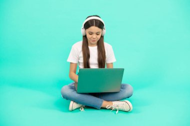 Gülümseyen çocuk video görüşmesi için kablosuz bilgisayar kullan ya da kulaklıkla webinar dinle, okula dön.