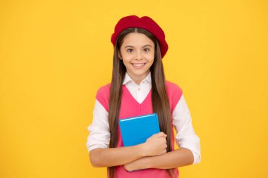 Okula dönüyorum. Berelineşeli çocuk çalışmaya hazır. Kitapla gülümseyen çocuk. Genç bir öğrenci. Gençlik ve gençlik. Eğitim. Mutlu Fransız genç kız defterini tutuyor. çocukluk mutluluğu.