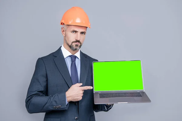 Man Met Helm Wijzende Vinger Groen Scherm Moderne Draadloze Laptop — Stockfoto