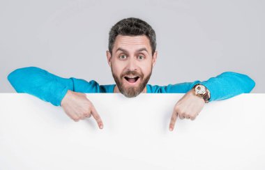 Kopya uzayı üzerinde işaret parmağı. Terfi ve yaratıcılık için bir yer. Pazarlama tasarımın. Kağıt pankartlı bir adam şaşırdı. Adam duyuru yapıyor. Erkek, kağıt çarşafın arkasında. kullanışlı bilgi için yer.