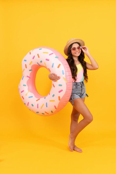 summer vacation. happy girl in straw hat and sunglasses inflatable doughnut ring. child hold beach accessory of inflatable circle swimming ring. active childhood. summertime kid weekend. suntan.