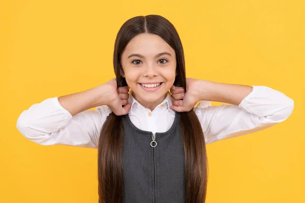 Glückliches Mädchen Kind Schuluniform Lächeln Hält Lange Haare Gelb Hintergrund — Stockfoto