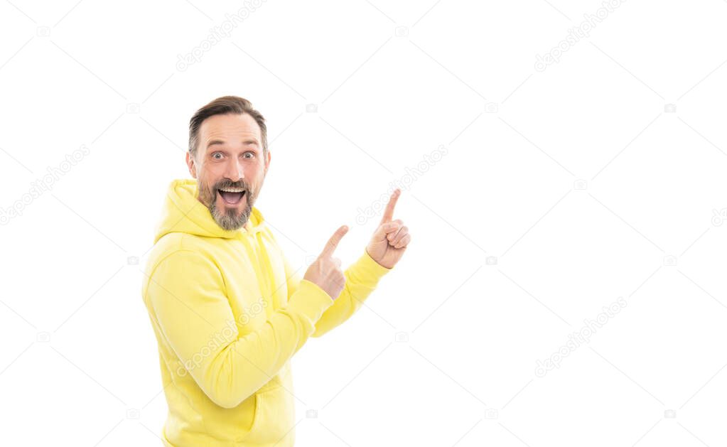 Advertising your brand. adult guy advertising. copy space. mature surprised man pointing finger. smiling senior guy presenting product isolated on white. advisor man in yellow hoody.