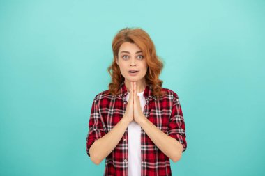 Kıvırcık saçlı, kareli gömlekli kızıl saçlı dua eden kadın, dua et..