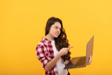 Öfkeli çocuk çevrimiçi. Bilgisayarda okul blogu. Video dersindeki çocuk. Genç kız dizüstü bilgisayarını işaret ediyor. Çevrimiçi eğitimde webinar. Okula dönüyorum. Modern iletişim. kötü internet bağlantısı.