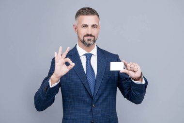 Her şey mükemmel. İş adamı kredi kartı ya da banka kartı gösteriyor. Boş plastik kartvizit. Başarılı CEO kolay bankacılık kar ödemesi öneriyor. Yakışıklı adam şovu tamam. Boz saçlı patron. Benimle irtibata geç.