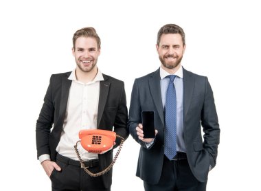 Hangi cihaz daha iyi. Erkekler cep telefonu ve telefon tutar. Cep telefonu ya da antika telefon kullanarak. Modern ve klasik iletişim. Teknoloji ilerlemesi.