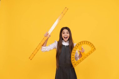 Mutlu çocuk okulda matematik açıölçer ve yönetici sarı arka planda, eğitim.