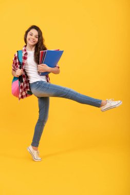 Mutlu enerjik kız çocuğu 1 Eylül 'de kitap ve sırt çantası taşıyarak okula koşuyor..