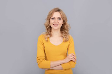 Güven. Kıvırcık saçlı kendine güvenen kadın. Güzellik ve moda. Kadın manken. Gülümseyen genç kızın güzel görünüşü. Sarışın kadın portresi. Olumlu duygularını ifade et. pürüzsüz yüz teni.