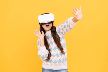 Mutlu genç kız sanal gerçeklikte eğitim için geleceğin teknolojisini kullanarak VR gözlükleri takıyor..