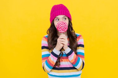 Lolipop bayan. Çubuklu lolipop şekerli hippi çocuk. Karamelli şeker dükkanı. Tatlı çocukluk hayatı. Diş bakımı konsepti. Tatlı düşkünü. Lezzetli. Şaşırmış genç kız lolipop tutuyor..