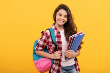 Gülümseyen öğrenci. Eğitim ve bilgi. Lisede. Not defteri ve sırt çantası olan bir kız öğrenci. Okula dönüyorum. Genç kız çalışmaya hazır. Mutlu çocukluk. Çocuk ödevlerini kitaplarla yapacak..