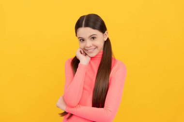 Sarı arka planda uzun saçlı mutlu çocuk, moda.