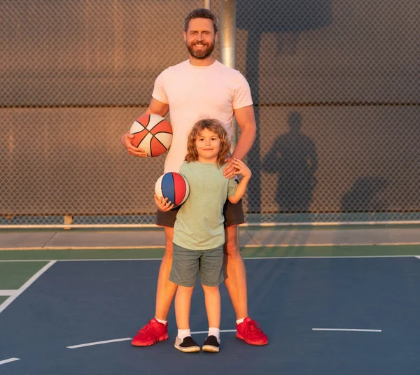 Feliz padre e hijo niño jugar baloncesto con pelota en el patio de recreo, día de los padres — Foto de Stock