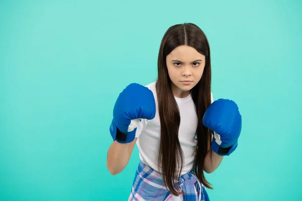 Concentrated kid boxer punching in boxing gloves during sport training, copy space, determination — Stock Photo, Image