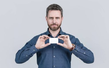 Sakallı, yakışıklı, olgun iş adamı. Fotokopi alanı ile kartvizitini gösteriyor..