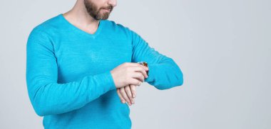 Kesilmiş adam zamanı kontrol ediyor. Kol saati olan adam. kopyalama alanı. Gelişigüzel giyinmiş bir adam..