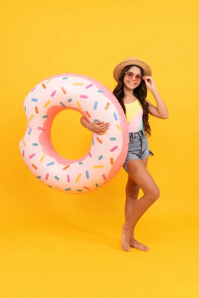 Opalenizna. letnie wakacje. szczęśliwa dziewczyna w słomkowym kapeluszu i okulary nadmuchiwane pierścień pączka. — Zdjęcie stockowe