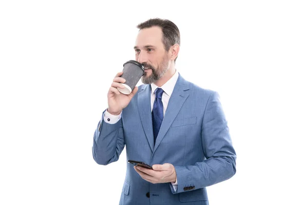Cheerful mature entrepreneur in suit drinking coffee and hold phone, morning coffee. — 스톡 사진