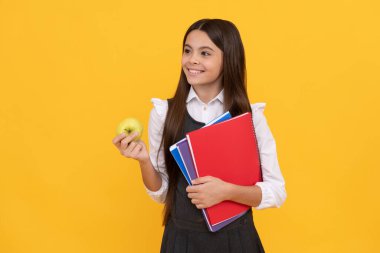 Okula tekrar hoş geldin. Elma ve kitap tutan mutlu çocuk gülümsemesi. Okula dönelim. Okula dönüş sezonu. 1 Eylül. Bilgi toplama günü. Temel eğitim.