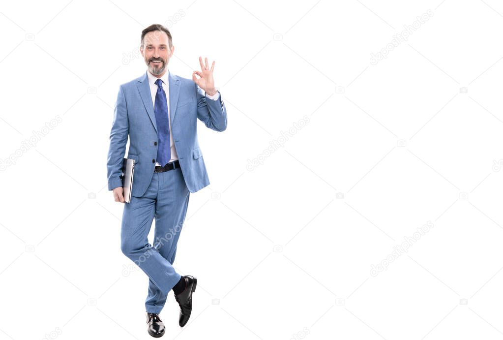 happy grizzled businessperson in suit full length holding computer isolated on white copy space, ok