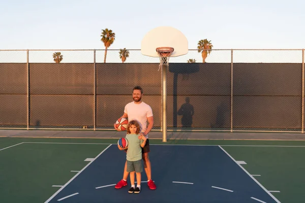 Feliz papá e hijo niño jugar baloncesto con pelota en el patio de recreo, paternidad — Foto de Stock