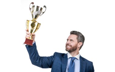 Takım elbiseli başarılı bir işadamı şampiyon kupasını beyaz tenli, başarılı bir iş adamı olarak elinde tutuyor..