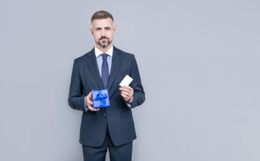 İş adamı kılığındaki kendine güvenen işadamı mevcut kutuyu paylaşıyor ve kredi kartı veya banka kartı tutuyor, satın alıyor.