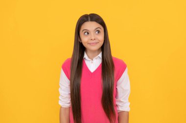 Hayalperest. Hayalperest çocuğun uzun saçları var. Deri güzelliği. Gençlik ve gençlik. Sıradan moda. Sarı arka planda genç bir kız. çocukluk mutluluğu. Okula dönüyorum. Düşünceli çocuk portresi.