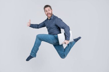 Enerjik patron bilgisayarı tutuyor. Baş parmak hareketi. Bilgisayarda çalışan zıplayan iş adamı. Başarı yolunda koş. Programcı bilgisayar kullansın. Girişimci koşuyor ve acele ediyor. çevik iş.