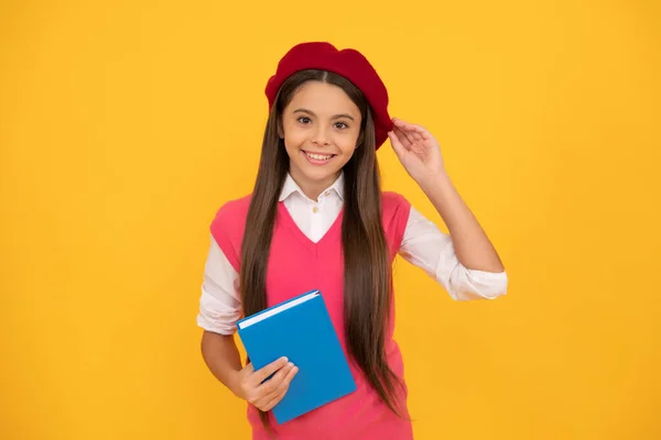 幸せなティーン学校の女の子でフランス語ベレー帽ホールドCopybook上の黄色の背景 — ストック写真
