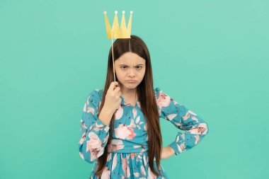 Angry selfish girl hold booth crown over head keeping arm akimbo blue background, egoist clipart