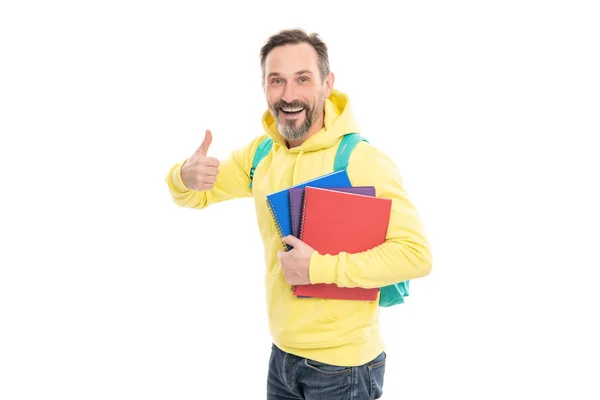 Счастливый человек носить рюкзак держать блокнот или рабочую тетрадь для образования изолированы на белом, большой палец вверх. — стоковое фото