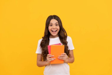 Şaşırmış okul çocuğu kitapla, bilgiyle çalışmaya hazır.