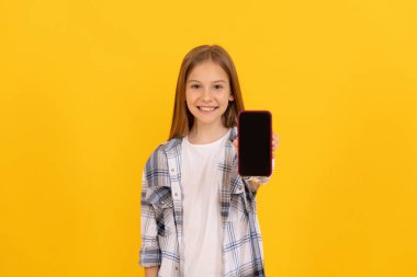 Mutlu çocuk modern akıllı telefon ürünlerini sunuyor. Kopya alanı ve reklam için ekranı gösteriyor.
