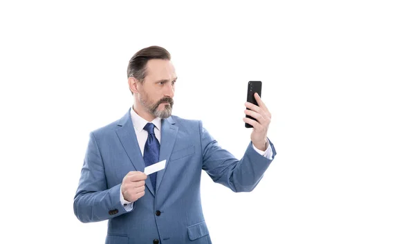 Seriöse reife Chef im Anzug halten Kreditkarte und Handy isoliert auf weiß, Selfie — Stockfoto