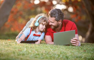 Okula dönüyorum. Baba ve oğul parkta modern iletişim teknolojisini kullanıyorlar. aile günlüğü
