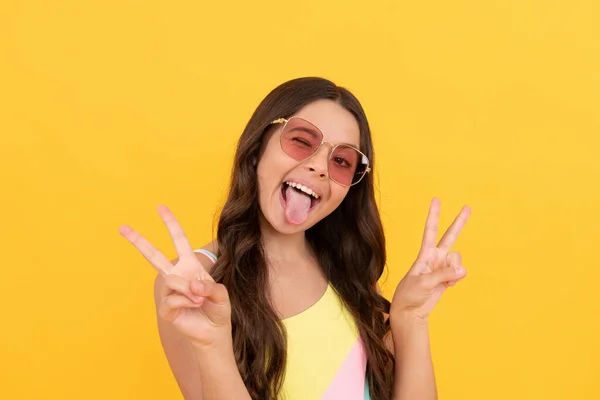 Happy kid in summer glasses has curly hair on yellow background, summer vacation — Stock Photo, Image