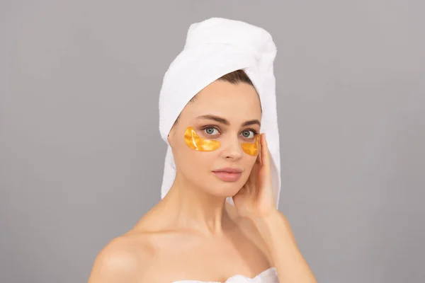 Wanita sensual dengan handuk terry menggunakan penutup mata emas wajah untuk kulit, spa — Stok Foto