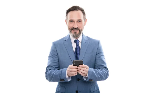 Усміхнений зрілий бос в бізнес-подібному костюмі обміну повідомленнями на телефоні ізольований на білому, балачки — стокове фото
