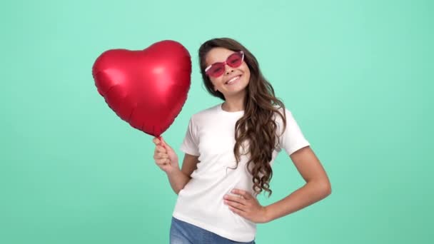 Портрет счастливого ребенка, позирующего с воздушным шаром сердечной вечеринки на 14 февраля праздник, романтический праздник — стоковое видео